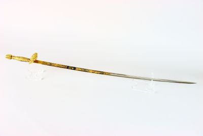 une vieille épée avec un manche en bois sur une surface blanche