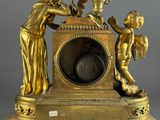 a gold clock with a statue on top of it