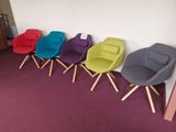 plusieurs chaises de différentes couleurs alignées contre un mur dans une pièce