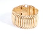 une image d'un gros plan d'un bracelet en or sur un fond blanc
