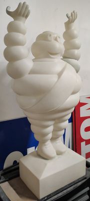 une statue blanche représentant un homme les mains en l'air