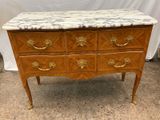 a marble top chest of drawers with gold handles