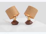 a pair of wooden lamps with burlock lampshads on a white surface