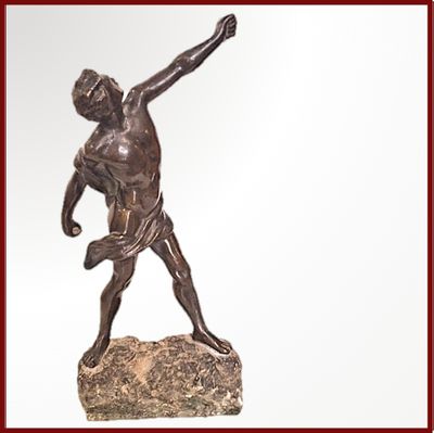 statue en bronze représentant un homme lançant un frisbee depuis le sommet d'un rocher