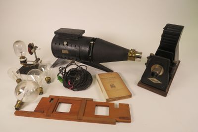 a table with a lamp, a lamp bulb, a book, and other items on it