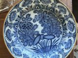 une assiette bleue et blanche posée sur une table en bois