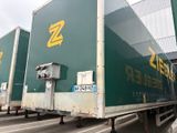 trois semi-remorques garées sur un parking