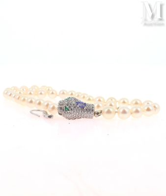 a close up of a white pearl bracelet with a diamond clasp