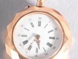 a gold pocket watch with roman numerals on it