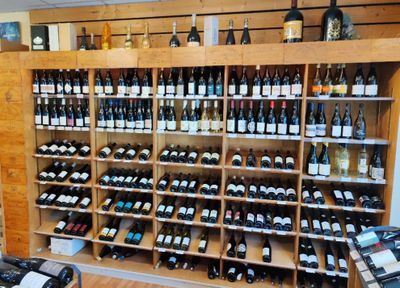de nombreuses bouteilles de vin sur les étagères du caviste