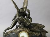 a bronze statue of a woman sitting on a clock