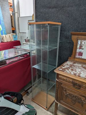 une vitrine en verre dans le coin d'une pièce