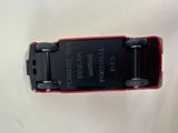 a small red cell phone sitting on a white surface