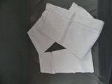 une pile de serviettes blanches pliées sur un canapé noir