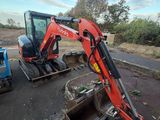 une petite pelleteuse garée sur le bord de la route