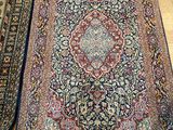 two rugs on the floor in a room with wooden flooring