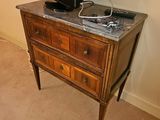 une télévision posée sur une commode dans un coin de la pièce