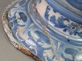 a blue and white vase with a bird on top of it
