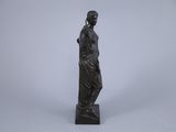 a bronze statue of a woman standing on a pedestal