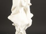 une statue blanche représentant une femme portant un voile sur la tête