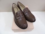 they are two pairs of brown loafers on a pink box