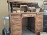un bureau en bois muni de tiroirs et surmonté d'une bibliothèque