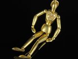 a gold figurine of a man sitting on a black surface