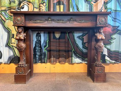 tableau accroché au mur d'une pièce où se trouve une cheminée