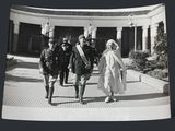 black and white photograph of a group of people walking in a courtyard
