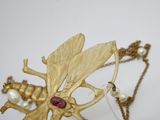 un gros plan d'un collier orné d'une libellule