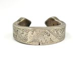 a close up of a silver cuff with a design on it