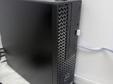 a black computer sitting on a white surface next to a mouse