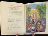 someone is holding a book open to a picture of a woman and a man
