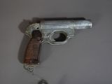 un vieux pistolet accroché au mur à côté d'une souris