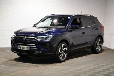 un 4x4 bleu garé dans un garage au sol en damier