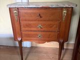 a small marble top cabinet in the corner of a room