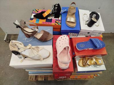 Plusieurs paires de chaussures pour femmes sont empilées sur des cartons