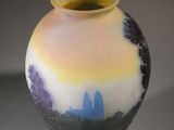 a vase with a painting on it sitting on a table
