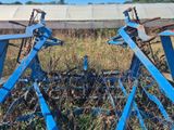 une charrue bleue au milieu d'un champ