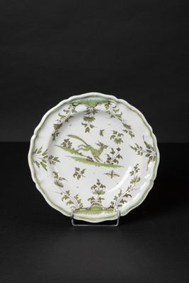 a green and white plate with birds and flowers on it