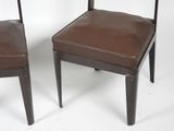 pair of brown leather dining chairs with metal legs and backrests