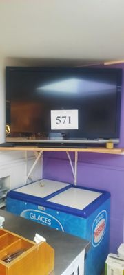 une télévision à écran plat fixée au mur au-dessus d'une table