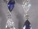 pair of sapphire and diamond earrings on display in a glass case