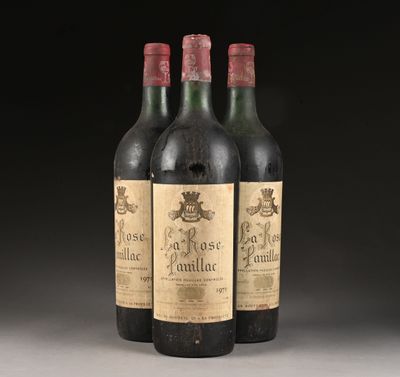 trois bouteilles de vin sont posées sur une table devant un fond noir