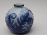 a small blue and white vase with a black lid