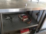 a stainless steel table with a book shelf underneath it