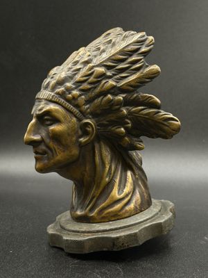 a close up of a bronze statue of a man wearing a headdress