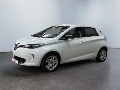 La voiture blanche est garée dans une pièce au sol gris.