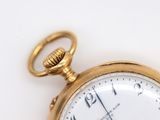 a close up of a pocket watch on a white surface