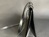 silver leather purse with strap on a grey background